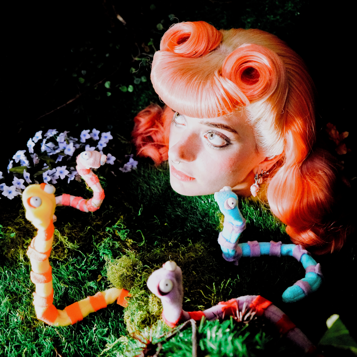 Sophie's head in a garden surrounded by felt worms